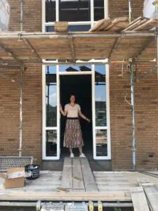 Locatiemanager van Het Blaauwhofhuis in Joure in de deuropening van de kleinschalige woonzorglocatie voor mensen met dementie