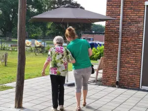 De GVP wandelt samen met een bewoonster door de tuin van een woonzorglocatie van Dagelijks Leven. Foto bij de blog over verdriet en eenzaamheid bij dementie.