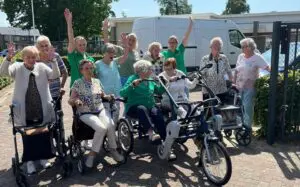 De bewoners van Het Picardthuis en Het Drostenhuis juichen bij het in ontvangst nemen van de duofiets. voor beide huizen is deze wens gerealiseerd: twee duofietsen!