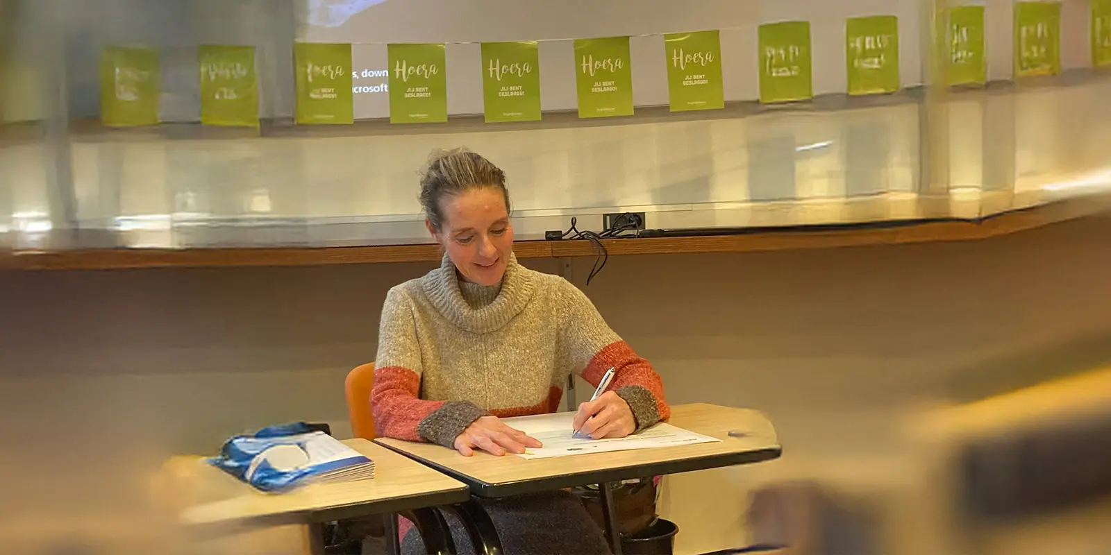 Foto van blogger die handtekening zet onder haar diploma GVP. Ze volgde de opleiding bij Dagelijks Leven.