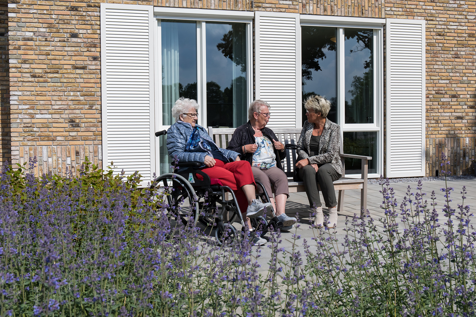 bewoners en familie van Het Vechtdalhuis in Hardenberg zitten buiten voor een gezellig gesprek