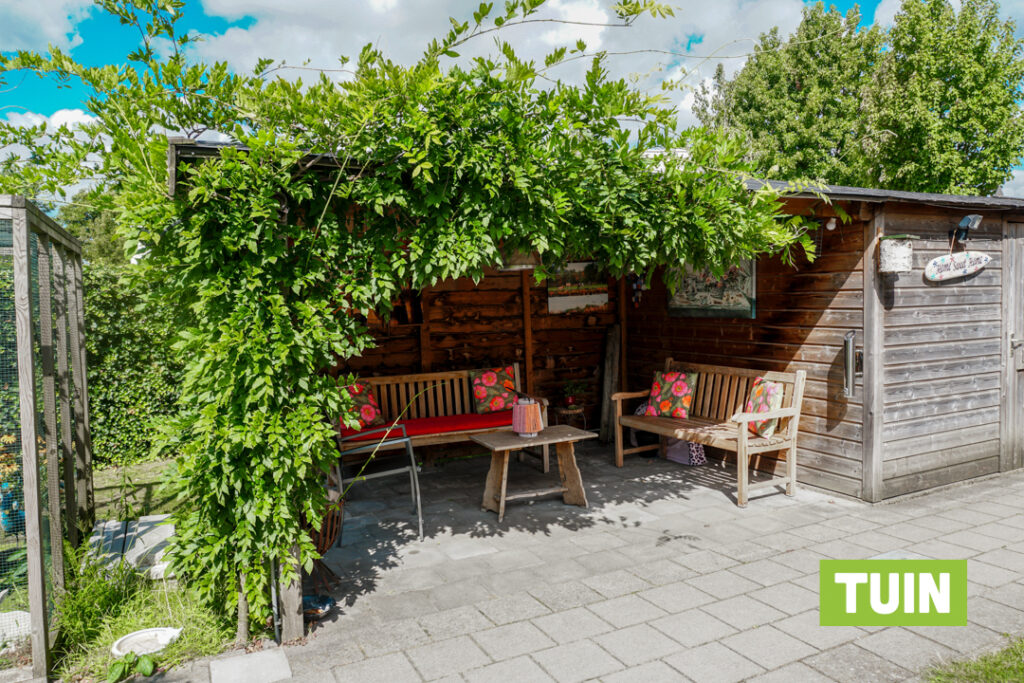 In de tuin van Het Stoofhuis staat een overkapping waar een heerlijk terras is gecreëerd voor de bewoners