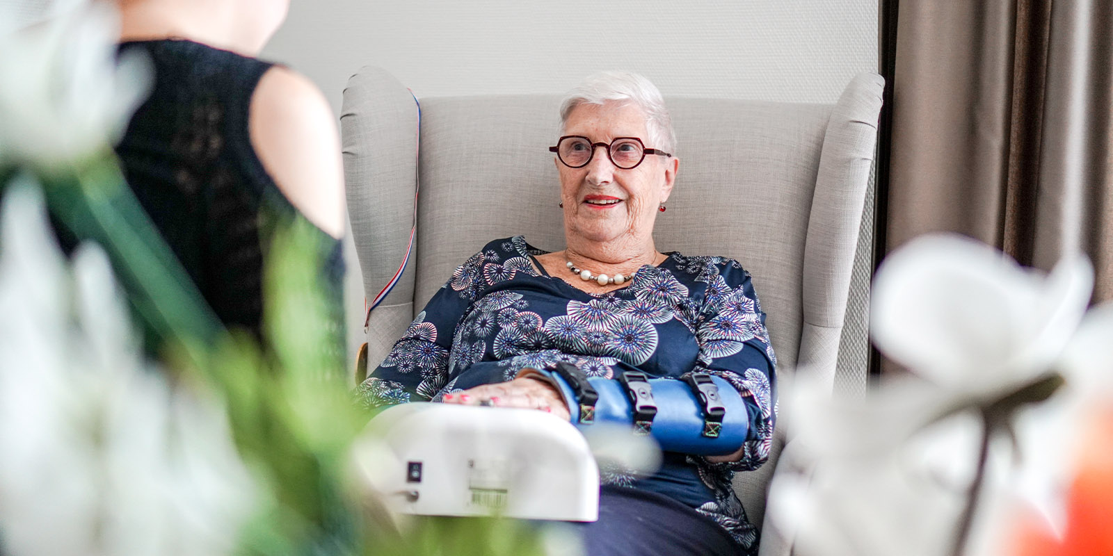 Een bewoonster met dementie van Dagelijks Leven wordt behandeld door een zorgprofessional die langs komt in het huis