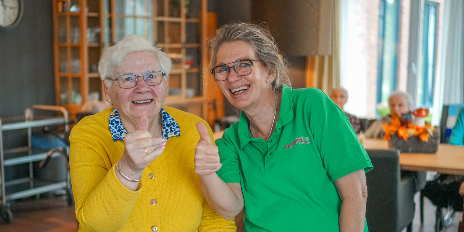 Een bewoonster met dementie en een verzorgende ig zijn blij met de nominatie van Dagelijks Leven in de beste 10 verpleeghuizen van Nederland volgens ZorgkaartNederland