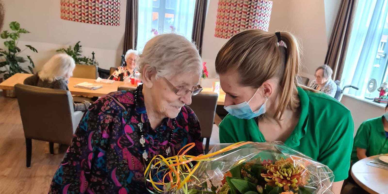 Een bewoonster van Het Hurkhuis krijgt een bos bloemen van de burgemeester omdat ze met haar 102 jaar de oudste inwoner van Helmond is.