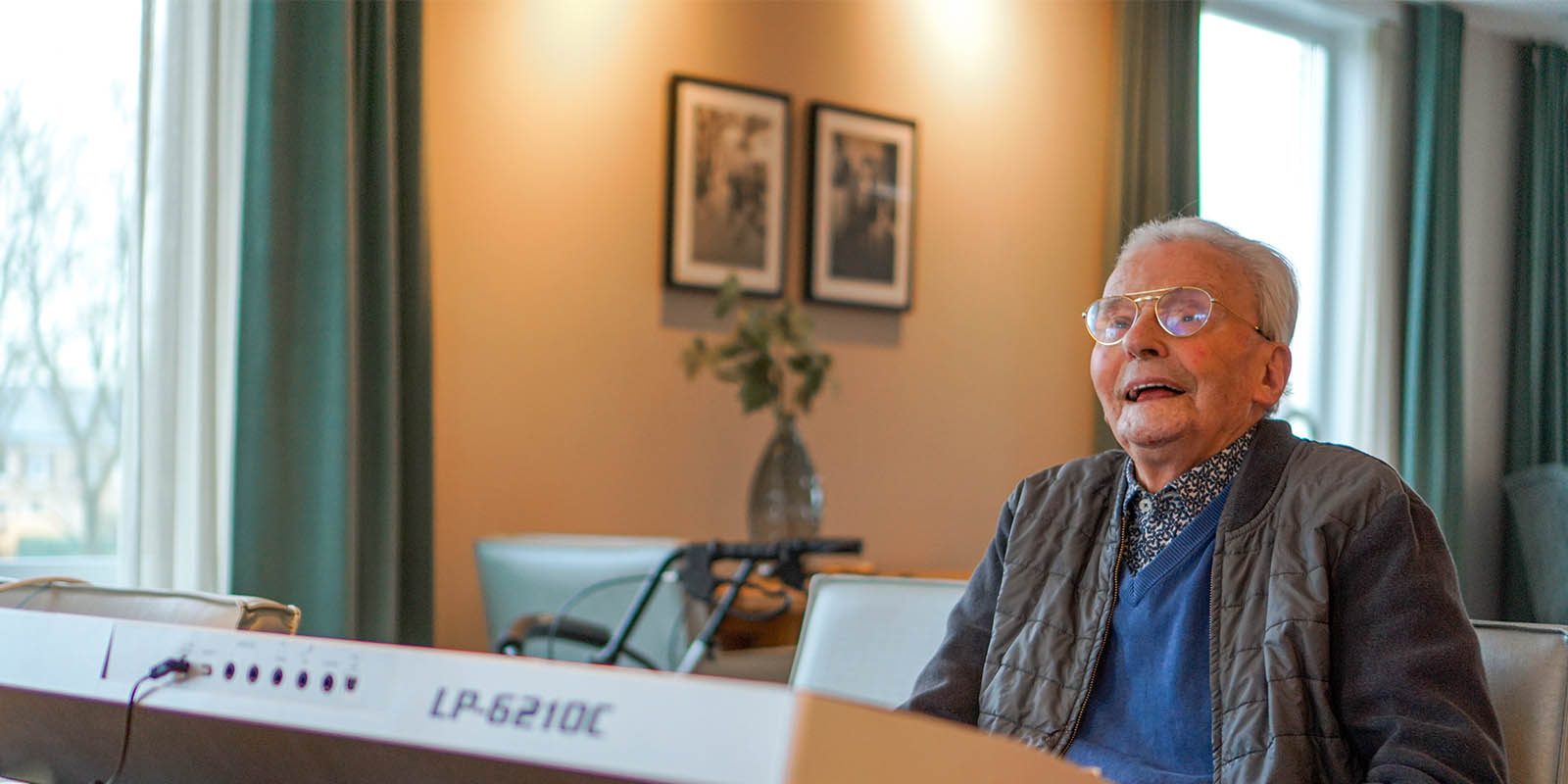 Bewoner van Het Blaauwhofhuis in Joure, wonen met zorg voor mensen met dementie in Friesland, achter het keyboard waar hij nog altijd graag op speelt. Nu hij 100 is, is hij de muziek soms wel een beetje kwijt.