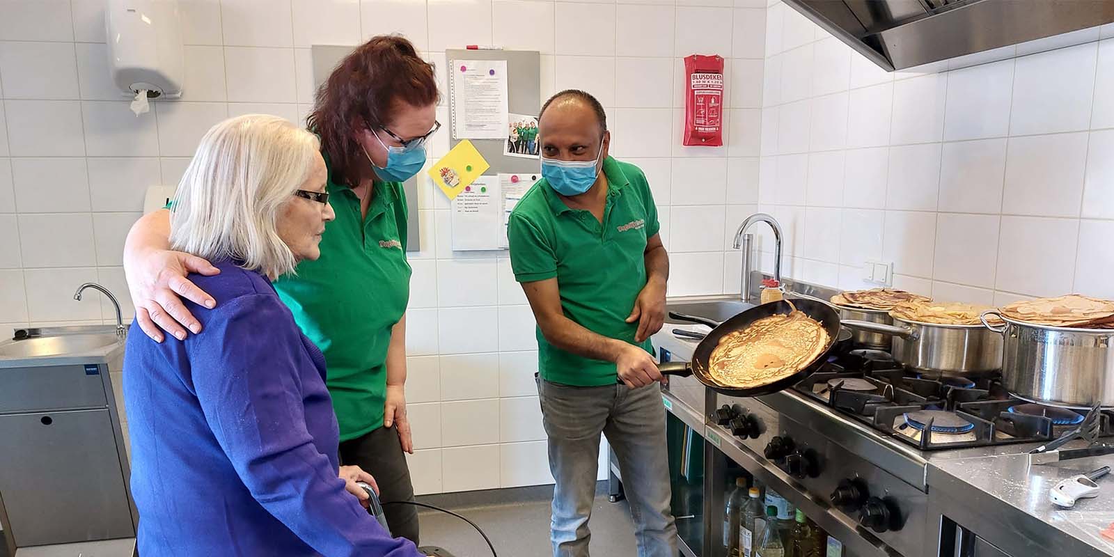 bij Dagelijks Leven is Nationale Pannenkoekdag goed gevierd! Op de foto twee medewerkers met een bewoner in de keuken van Het Venenhuis, aan het pannenkoeken bakken.