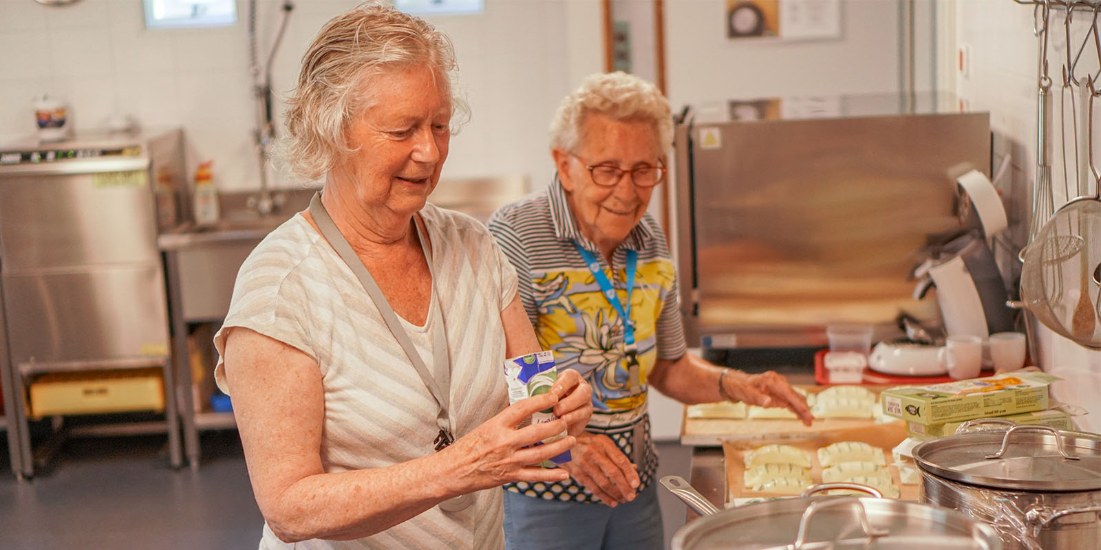 Twee bewoonsters aan het koken in de keuken van een woonzorglocatie van Dagelijks Leven. Foto ter illustratie bij het bericht over de kok van Het Markiezaathuis, die genomineerd is voor een Voeding in de Zorg-medewerker van het jaar.