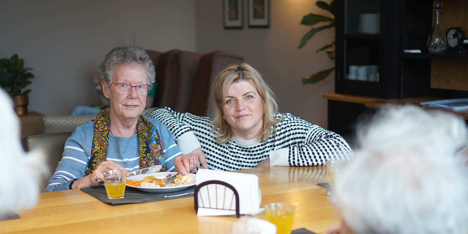 Irene de Jong samen met een bewoner aan tafel in Het Houwinghuis, kleinschalige woonzorglocatie voor mensen met dementie in Den Helder.