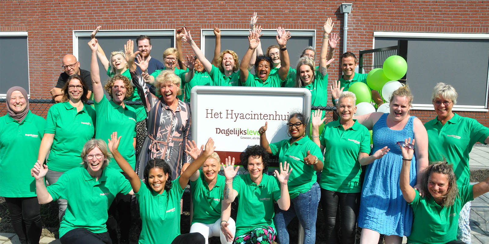Foto van het juichende team van Het Hyacintenhuis tijdens de opening. Samen met Het Bonedijkehuis, ook in Vlissingen, viert het huis eindelijk een groot feest omdat beide woonzorglocaties voor mensen met dementie hun plek in Vlissingen gevonden hebben.