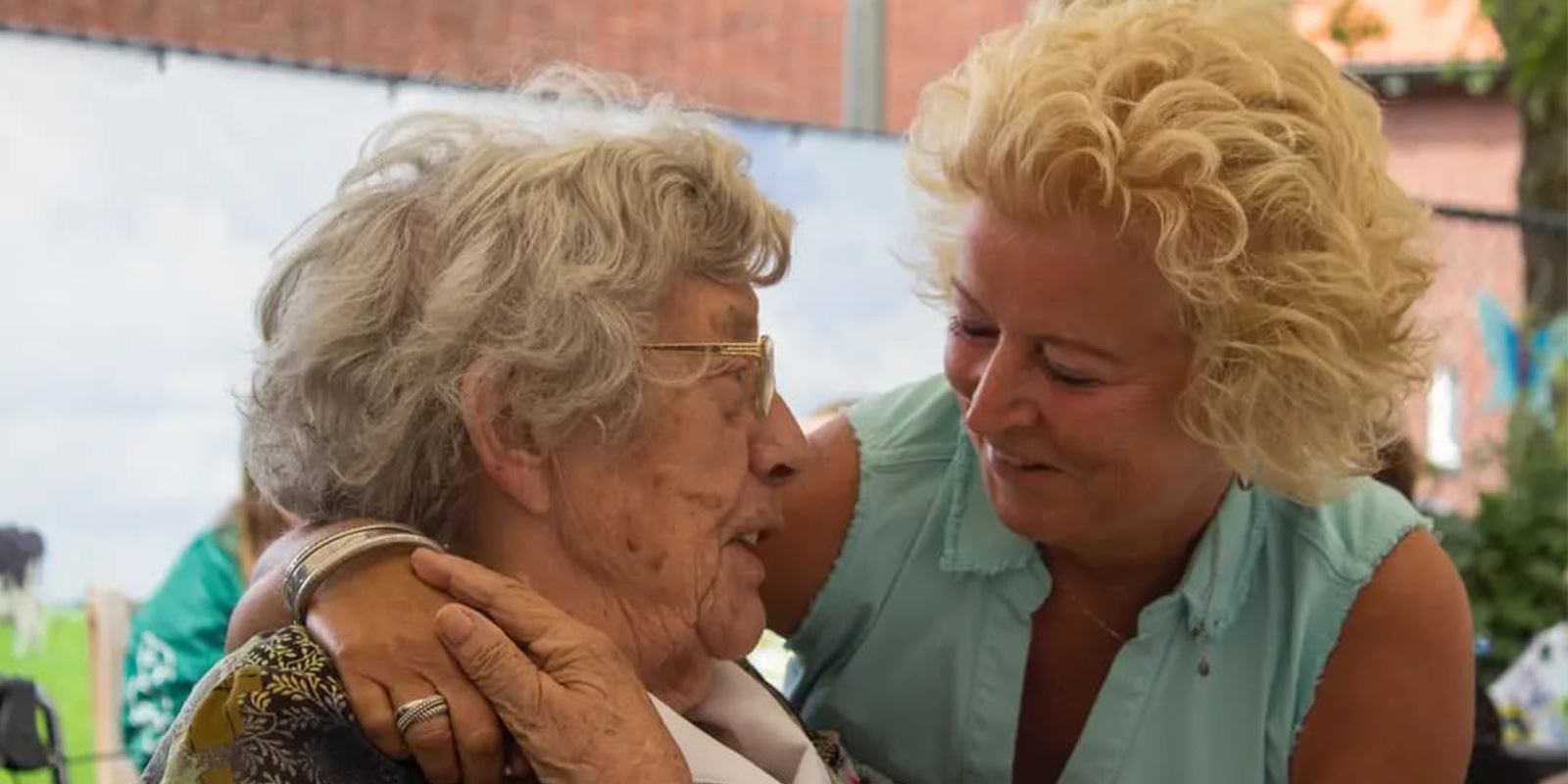 Het Beatrixhuis, woonzorglocatie voor mensen met dementie, vierde feest vanwege het vijfjarig bestaan. Op de foto een bewoner, knuffelend met een verwant. Ze kijken blij naar elkaar.