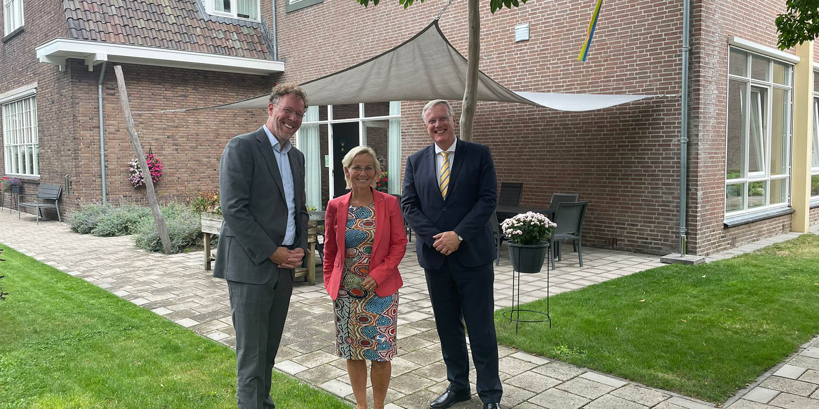 Commissaris van de Koning van de provincie Overijssel, Andries Heidema, bracht een bezoek aan Het Hofstedehuis in Raalte. Heidema staat voor het huis op de foto met de locatiemanager van het huis en de directeur van Dagelijks Leven.