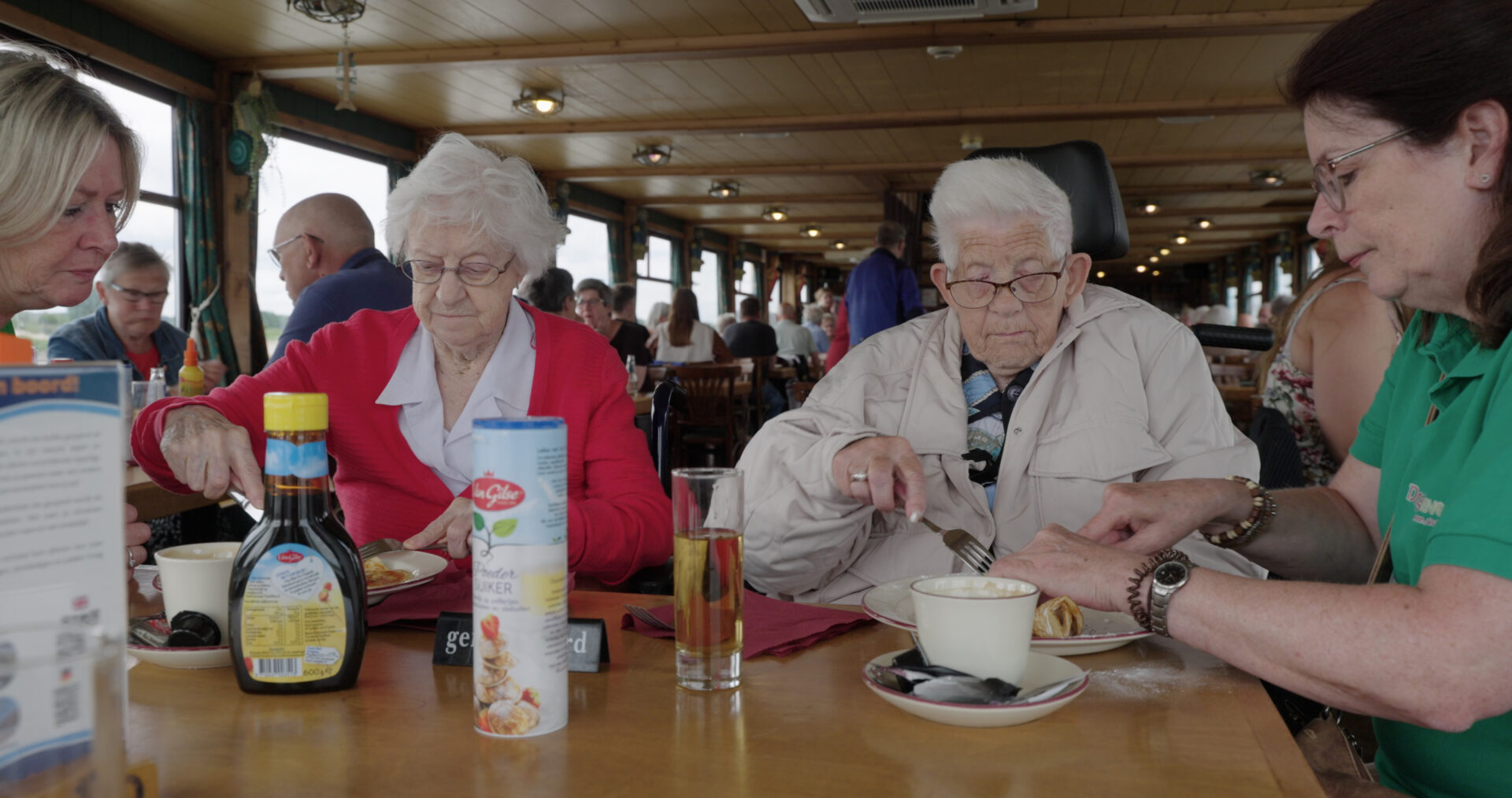 Tonnie en Ine, beide woonachtig in een kleinschalige woonzorglocatie voor dementie, eten een pannenkoek op de pannekoekenboot in Nijmegen.