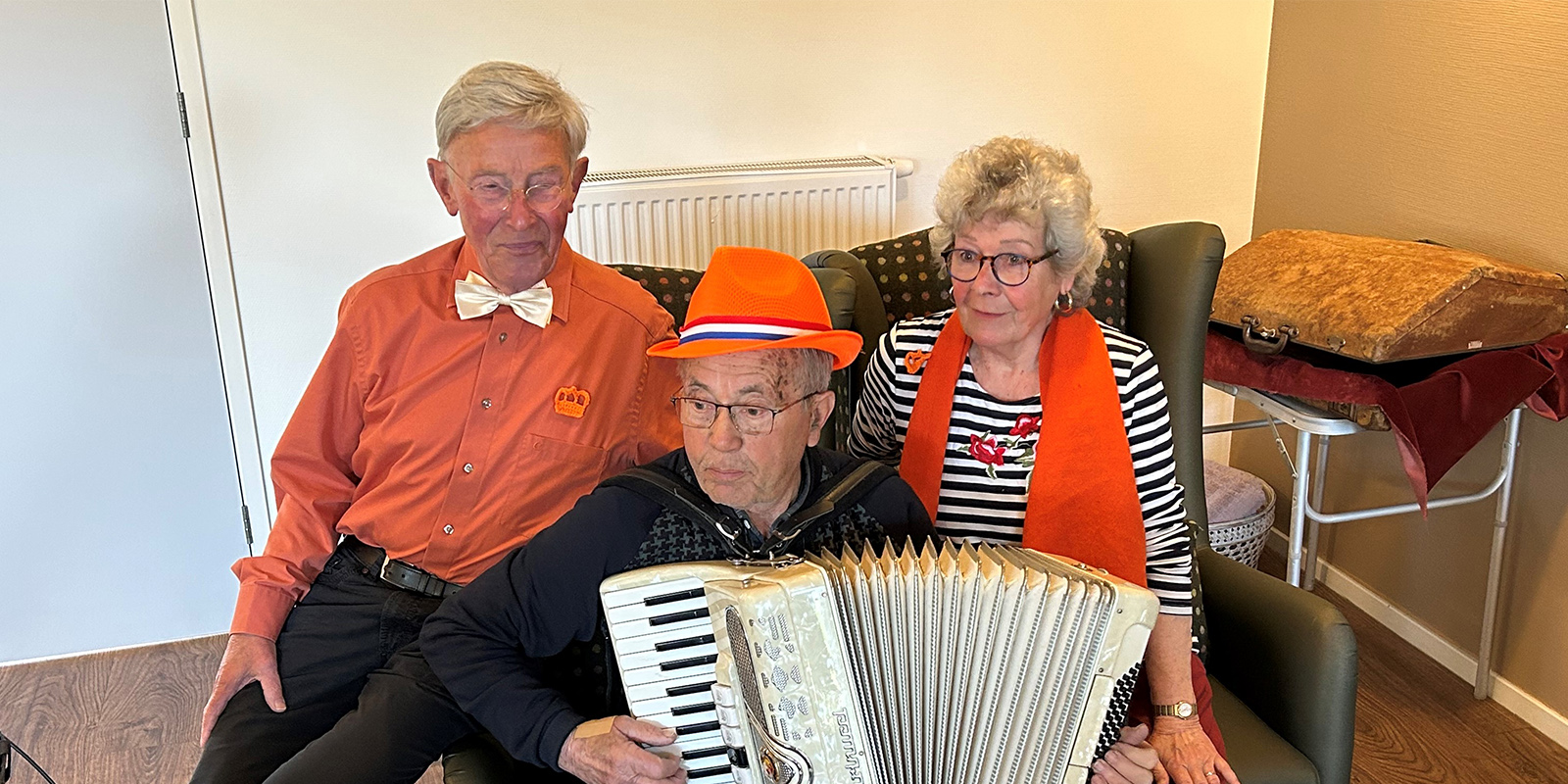 Vrijwilligers zijn onmisbaar in de zorg voor dementie. Hier de drie muziekvrijwilligers, met in het midden de accordeonspeler wiens jas verdween.