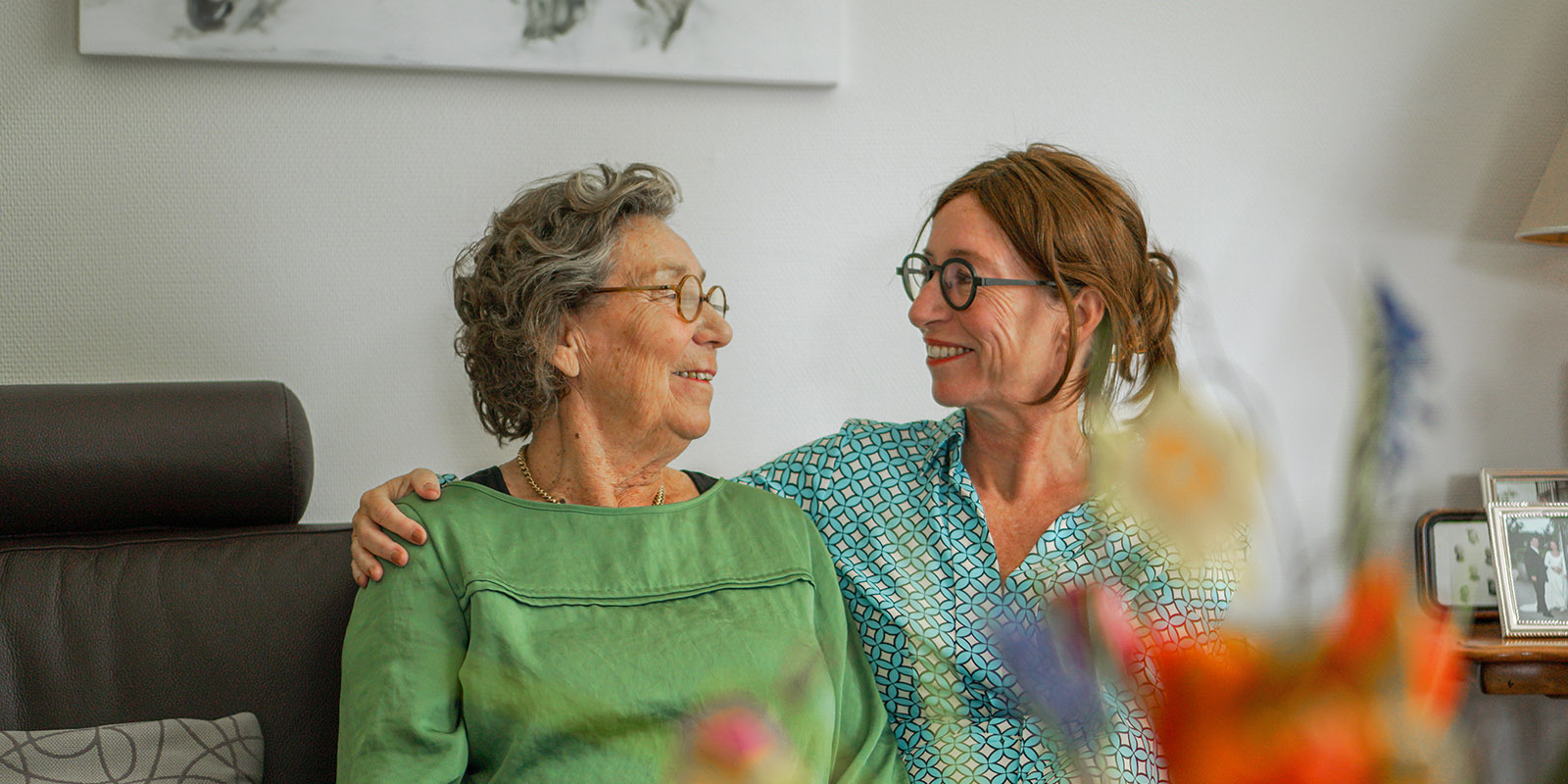 Moeder en dochter samen op de bank in haar studio in Het Boomgaardhuis in Geldermalsen, voor mensen met dementie.