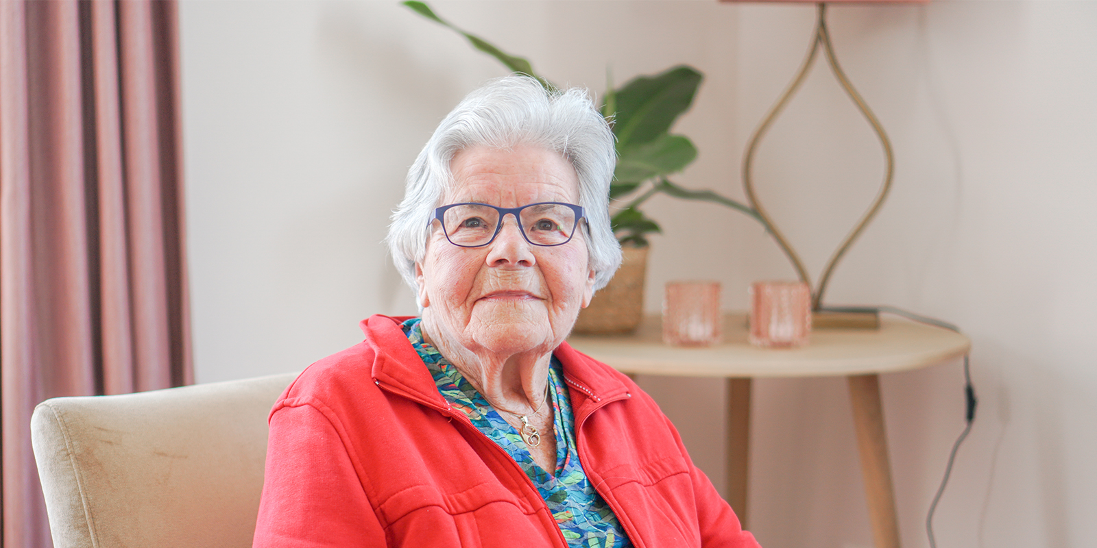Portretfoto van een bewoonster van Het Snijdelhuis, een nieuwe kleinschalige woonvorm voor mensen met dementie in Boskoop. Zij vertelt waarom ze het daar zo fijn wonen vindt.