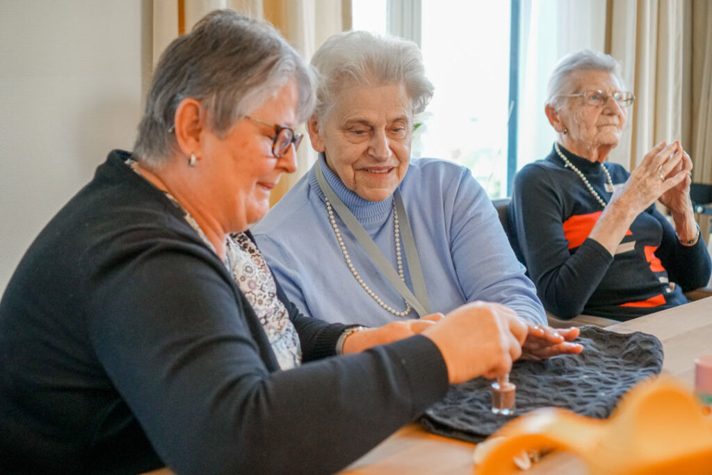 Een vrijwilligster en bewoonster lakken hun nagels in de woonzorglocatie van Dagelijks Leven voor mensen met dementie