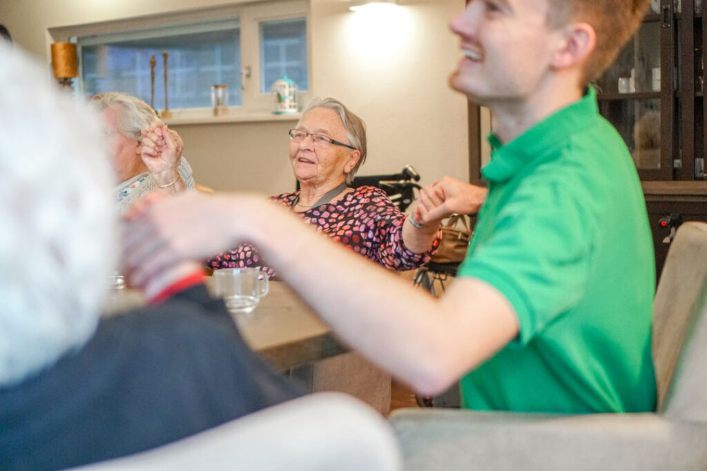 De bewoners van de locatie van Dagelijks Leven voor mensen met dementie zingen en dansen mee tijdens de muziekmiddag